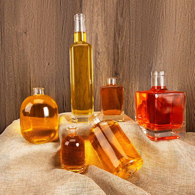 In gefüllten transparenten quadratischen Rundflächenflaschen