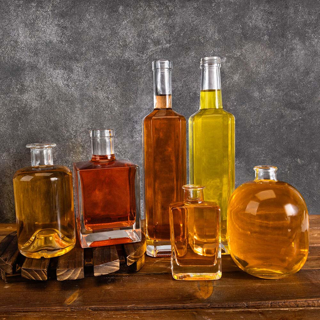 In gefüllten transparenten quadratischen Rundflächenflaschen